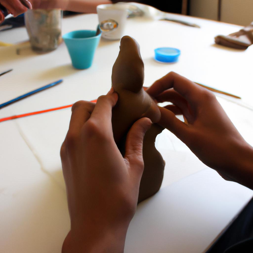 Person sculpting a clay figure